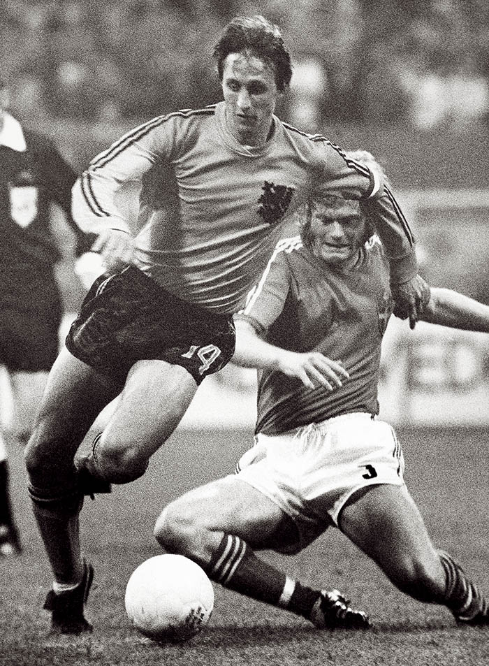 In this June 19, 1974, photo, Johan Cruyff, left, dodges a tackle attempt from Sweden's Kent Karlsson during a World Cup soccer match  in Dortmund, Germany. The Associated Press