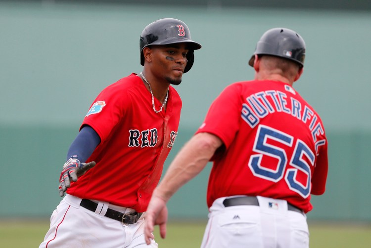 Boston Red Sox's Xander Bogaerts, left, and third base coach Brian Butterfield (55) celebrate Bogaerts solo home run off Philadelphia Phillies starting pitcher Jerad Eickhoff in the fifth inning of an interleague spring training baseball game, Sunday in Sarasota, Fla. The Associated Press