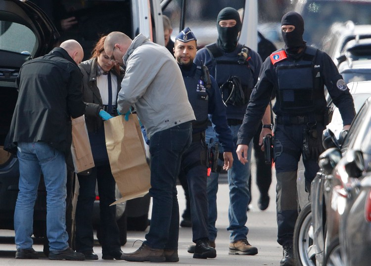 Police look at bags of evidence collected Friday during a search in the Brussels borough of Schaerbeek in connection with Tuesday's bombings in Belgium.