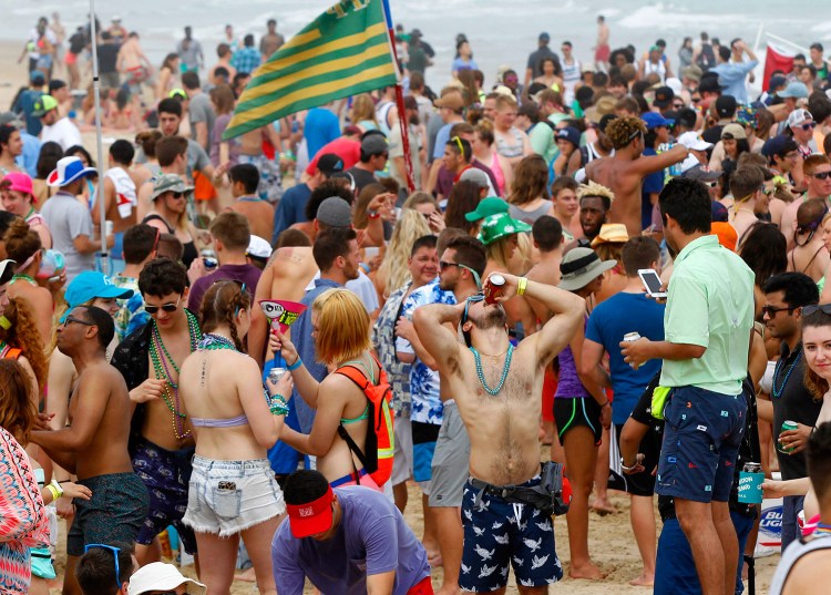 Spring break revelers crowd the beach Thursday at South Padre Island, Texas. In general, the more social interactions with close friends a person has, the greater their self-reported happiness. Recent research, however, finds that isn't true of smart people. 