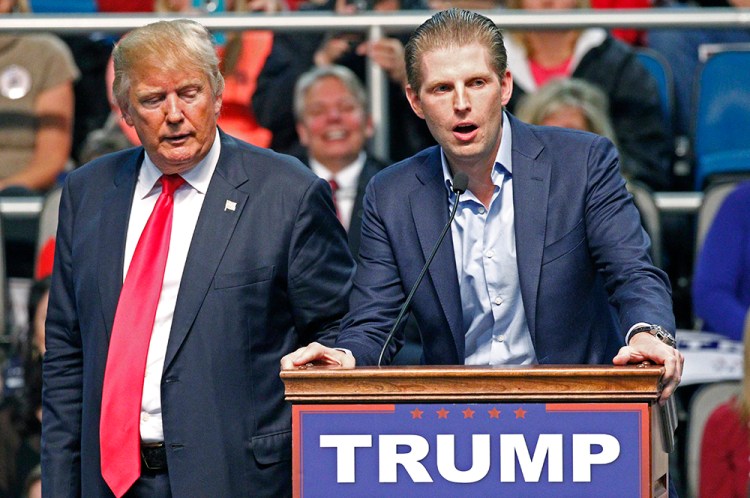 Republican presidential candidate Donald Trump listens as his son Eric Trump speaks during a rally in Biloxi, Miss., on Jan. 2. The Associated Press