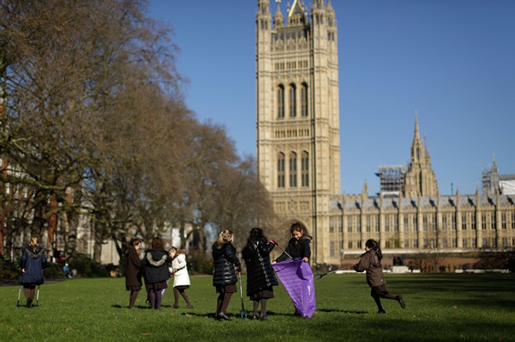 Pupils from Channing School in north London, look for litter as they pose for photographs in Victoria Tower Gardens, next to the Houses of Parliament in London.