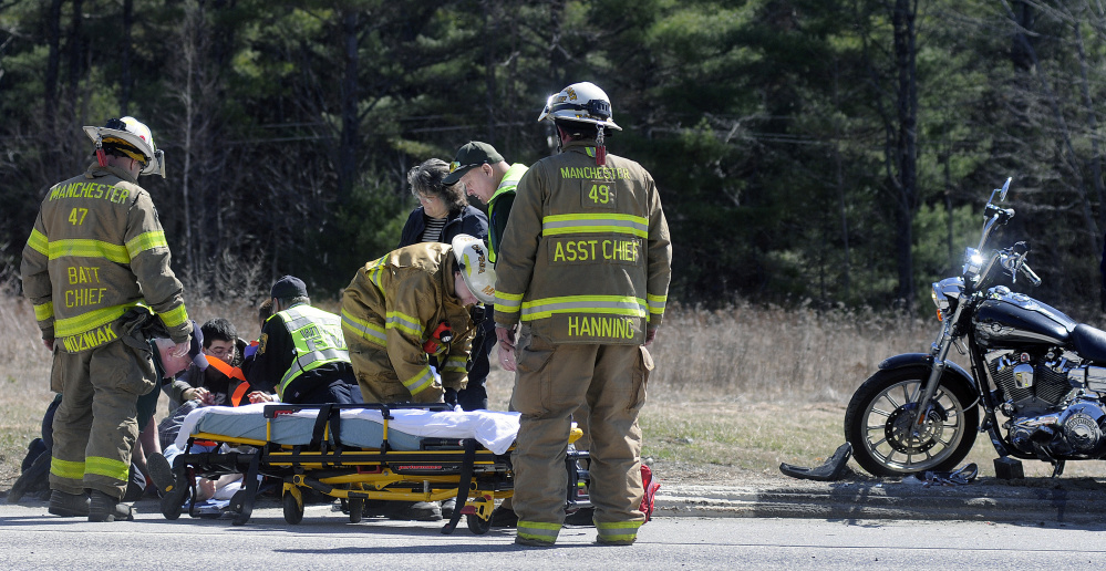 Emergency workers attend to Donald McLeod, 64, of Readfield, who was thrown from a motorcycle Thursday afternoon during an accident on U.S. Route 202 in Manchester.