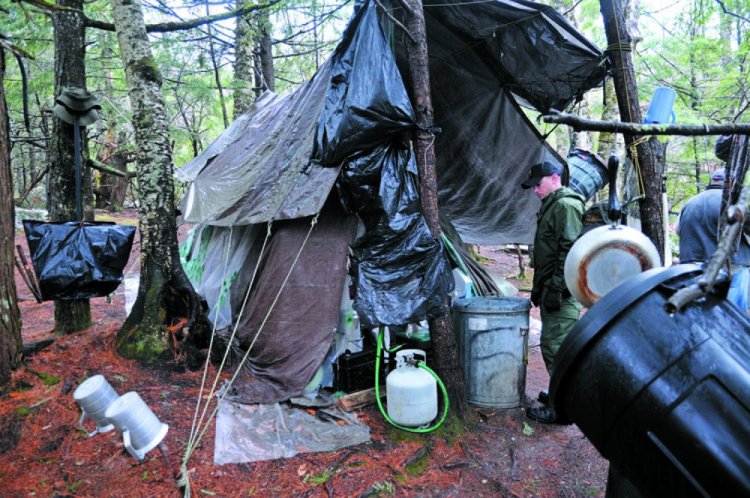 District Game Warden Aaron Cross inspects Christopher Knight's camp in a remote, wooded section of Rome in 2013.
Kennebec Journal file photo/Andy Molloy