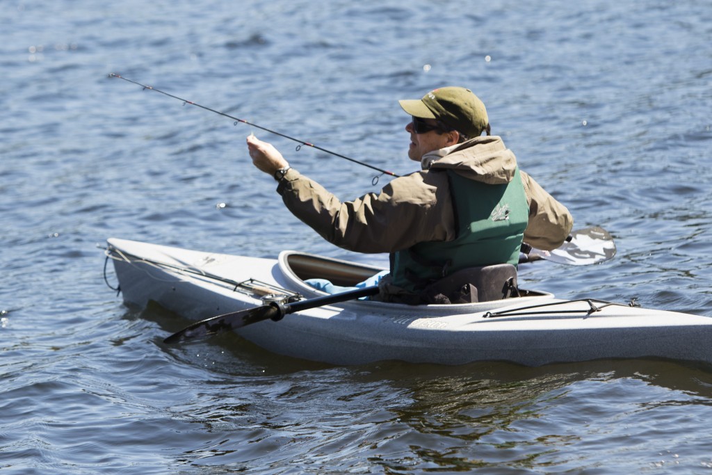 A self-employed entomologist whose travels enable him to fish all over the state – quite the fringe benefit – Clay Kirby of Orono gets ready to cast from his kayak on Crystal Lake, which is stocked annually with brook trout and land-locked salmon. 