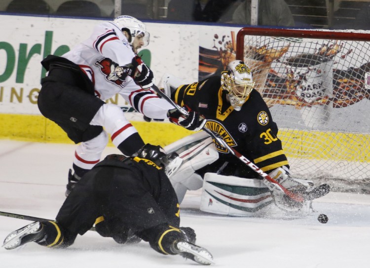 Wade Megan, left, of the Pirates tries unsuccessfully to slip the puck past Providence Bruins goalie Jeremy Smith during the third period Friday night at Cross Insurance Arena. The Pirates won, 2-0.