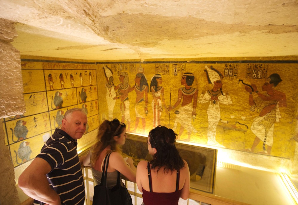 American tourists visit King Tutankhamun's burial chamber at his tomb at the Valley of the Kings in Luxor, Egypt, Thursday, March 31, 2016. A radar surveys is scheduled Thursday by Japanese radar technologist to confirm or deny claims that King Tutankhamun's tomb contains hidden undiscovered chambers. (AP Photo/Amr Nabil)