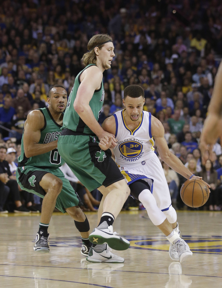 The Warriors' Stephen Curry dribbles around Kelly Olynyk in the first half. Curry missed a possible game-tying shot in the finals seconds of the game.
The Associated Press
