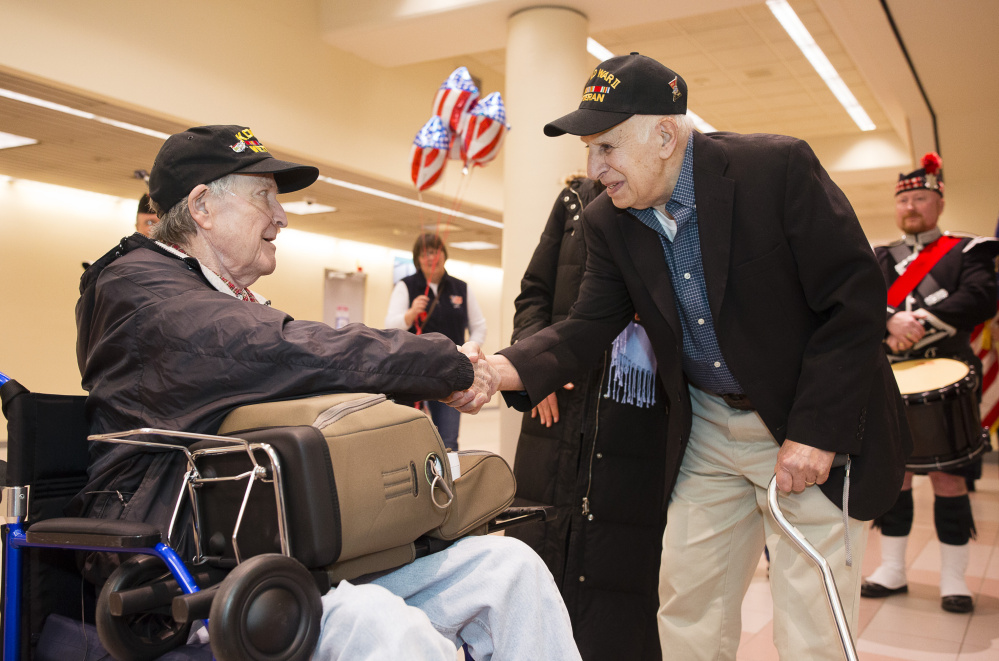 McCann is greeted by World War II veteran John Rappa during a reception Sunday at the Portland International Jetport. Rappa also went on an Honor Flight last fall.