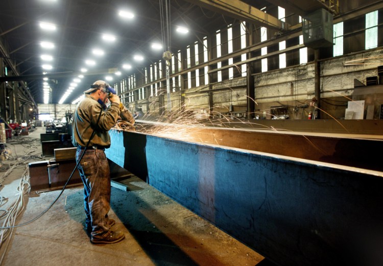 Casco Bay Steel employee Dustin Ford grinds a steel girder that will be used on a project in New Haven, Vt.. 