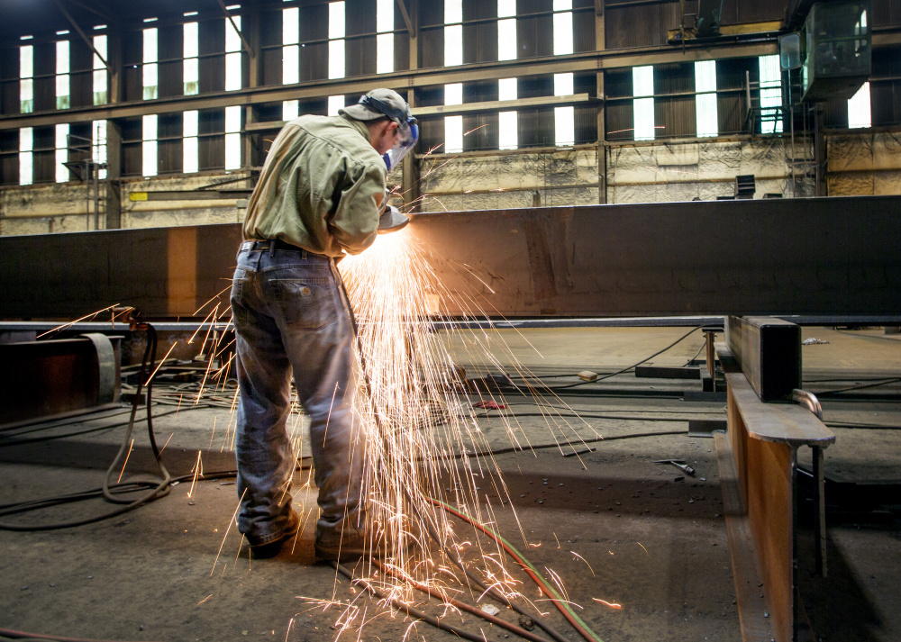 Dustin Ford grinds a steel girder at Casco Bay Steel.