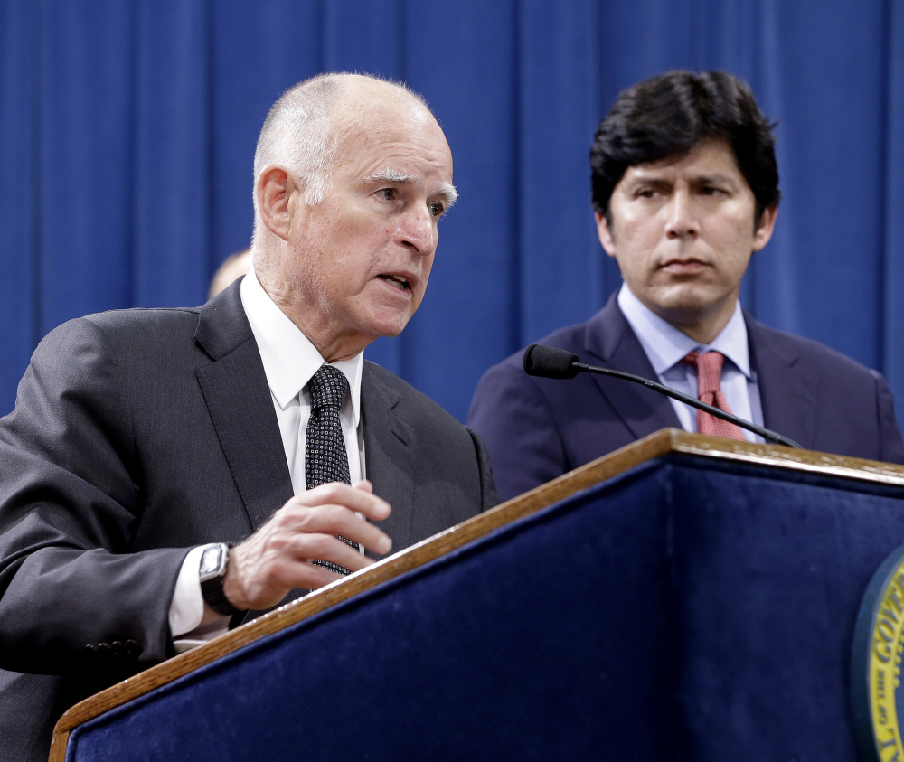 Accompanied by labor leaders and Senate President Pro Tem Kevin de Leon, D-Los Angeles, right, California Gov. Jerry Brown discusses proposed legislation to increase the state's minimum wage to $15 per hour by 2022, during a March 28 news conference in Sacramento.