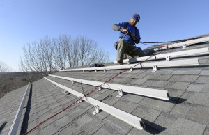 Zach Good of ReVision Energy prepares a roof for solar panels at a private home in Cape Elizabeth in 2015.