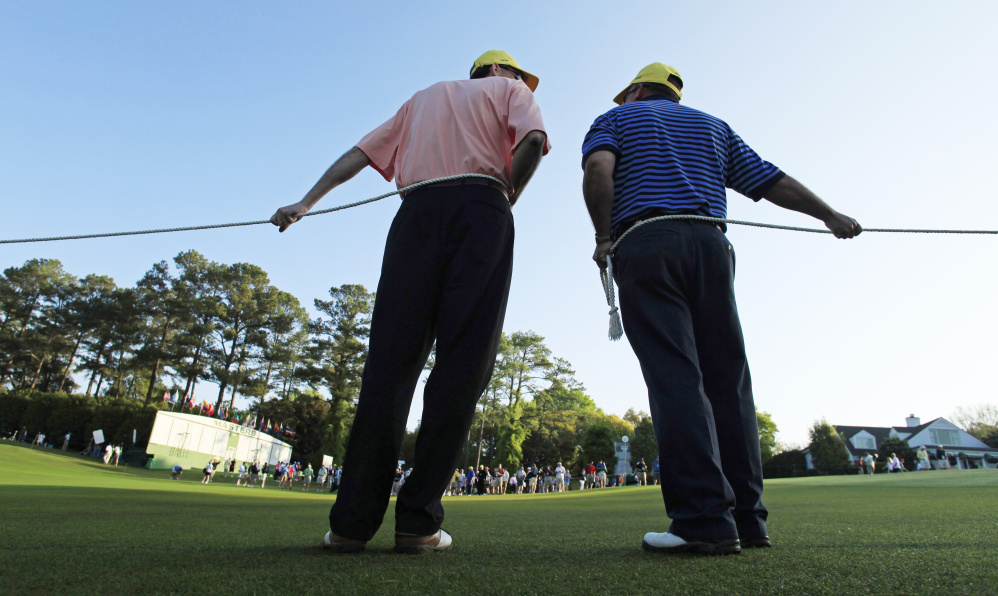 Gallery guards hold ropes to keep spectators off the first fairway at Augusta National in 2010. The three Mainers serving as volunteers again at this year's tournament, which starts Thursday, will also do crowd control and will direct fans along the walking paths.