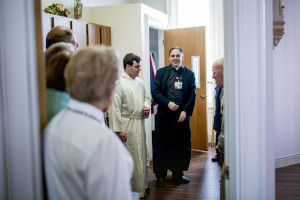 Rev. Paul Dumais meets with Mass attendees in the sacristy of the chapel at the d'Youville Pavillion at St. Mary's Hospital in Lewiston.