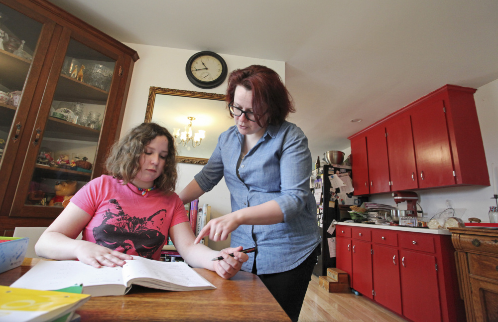 Homeschooling parent Lea Verrill helps daughter Clara with her math in North Yarmouth. Maine law doesn't do much to ensure that all homeschooled children get the well-rounded education they're entitled to.