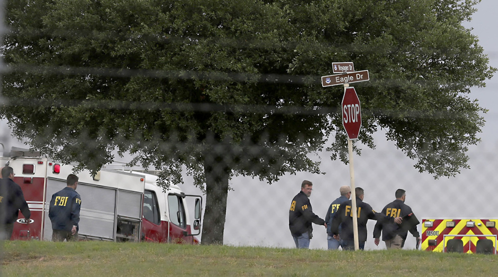 First responders and FBI agents gather near the scene of a shooting at Joint Base San Antonio-Lackland on Friday in San Antonio.