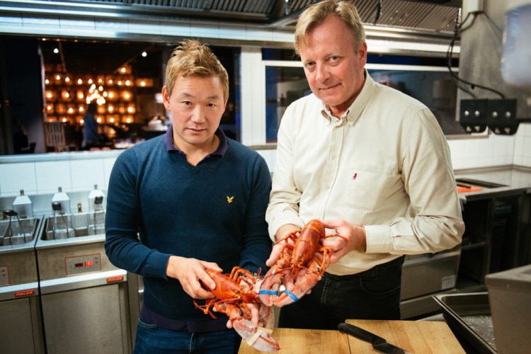 Thomas Dahlstedt, left, who co-owns and manages Stockholm's Burger & Lobster, and Chef Anders Westerholm hold cooked North American lobsters. A proposed import ban is "too dramatic," Westerholm said.