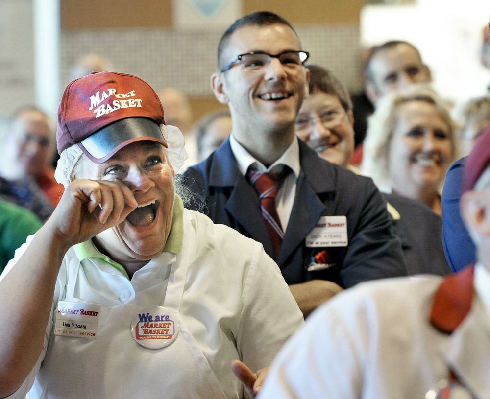 Lisa Lemieux from Salem, N.H. wipes away tears as she is joined by employees watching their new owner Arthur T. Demoulas speak during a news conference on a television at the Market Basket in Biddeford in August 2014.