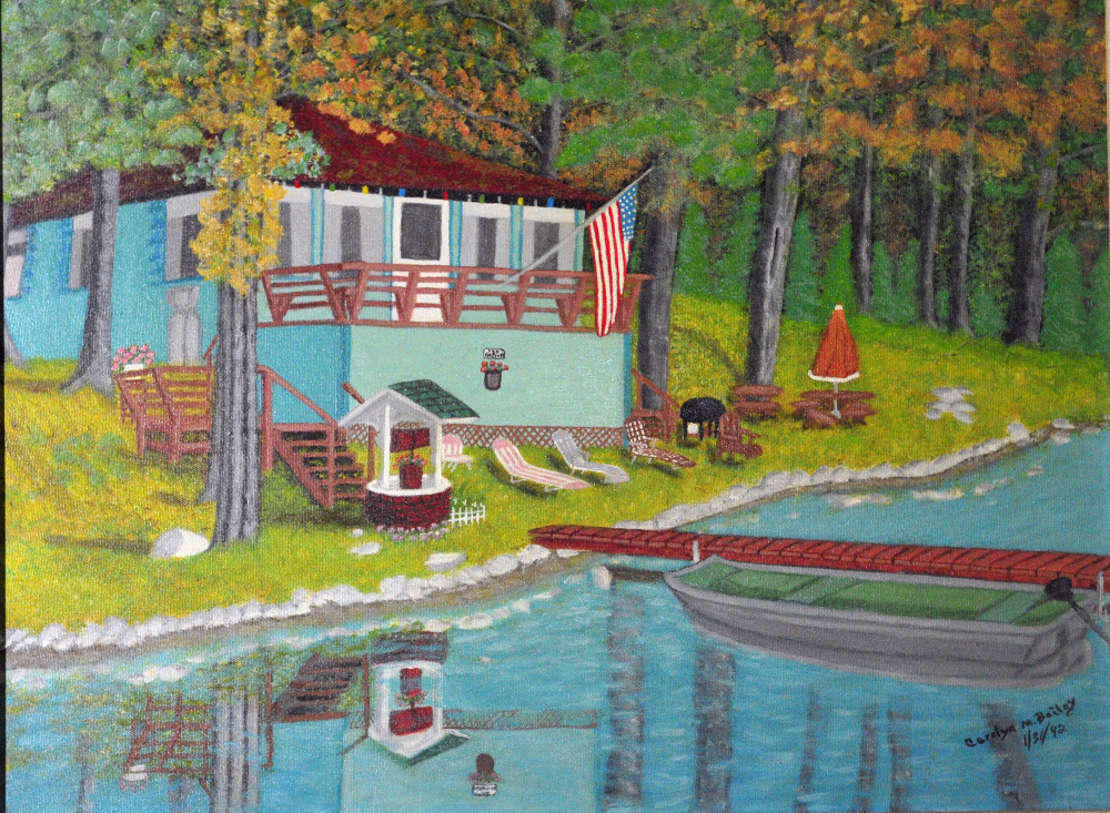 Carolyn Bailey's painting of a camp on Ward Pond in Sidney, which she and her family used to own, is seen last week in her Chelsea home.