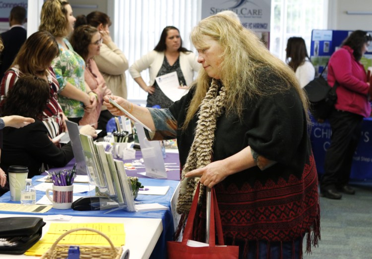 Lois Dersham, who lost her job when Merrymeeting Behavioral Health Services closed, checks out employers at a job fair in Brunswick in April. "I'd like to find a similar job, but now I worry a little about the field I'm in," she said.