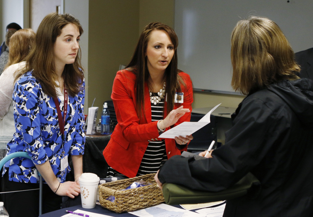 Elizabeth Keenan, center, and Brittany Tyner, left, of Eastern Maine Health Services, distribute employment information to former Merrymeeting employees.
