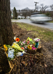 A car passes a makeshift memorial Tuesday at the site where Cole Amorello crashed early Saturday. Police say the Cape Elizabeth teenager was driving illegally with a learner's permit and had likely been drinking before the crash.