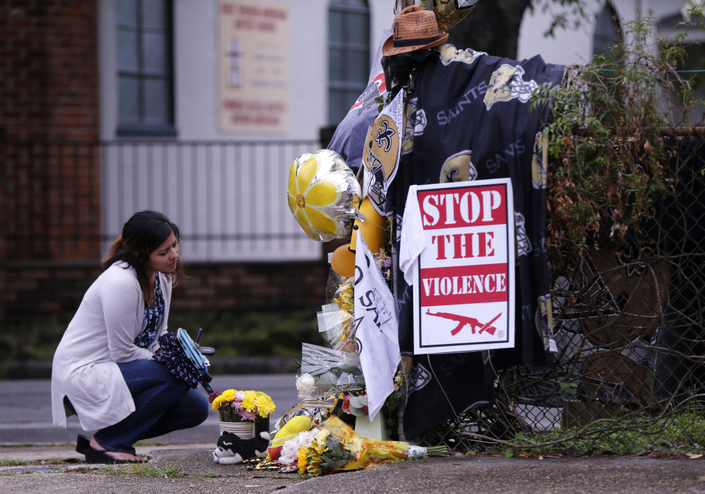 Gabriella Ortiz of New Orleans pauses at a makeshift memorial in New Orleans on Tuesday, near the spot where former Saints defensive end Will Smith was shot and killed, and his wife wounded after a traffic accident last Saturday.