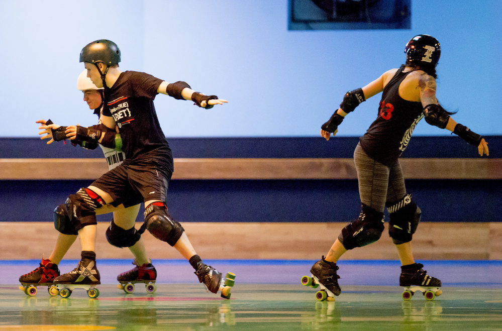 Leah "Cabbage Smash Kid" Farber, PJ "Shazzama Pajama" Koroski and Heather "Kirsten Damned" Tirado – members of the Maine Roller Derby league – practice Wednesday at Happy Wheels on Warren Avenue in Portland.