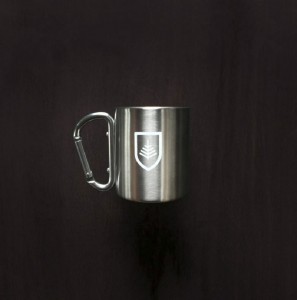 Products developed by Might & Main include, from left, an insulated mug with a carabiner handle; a baseball cap with a Dirigo patch; and enamel mugs.