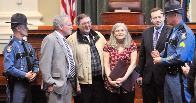 Maine State Police Trooper David Barnard, left, Rep. Richard S. Malaby, R-Hancock, Leonard and Rosemary Wallace, Speaker of the House Mark Eves and state police Sgt. Jason Sattler stand in the well of the House chamber during presentation of an award during the legislative session Thursday in Augusta.