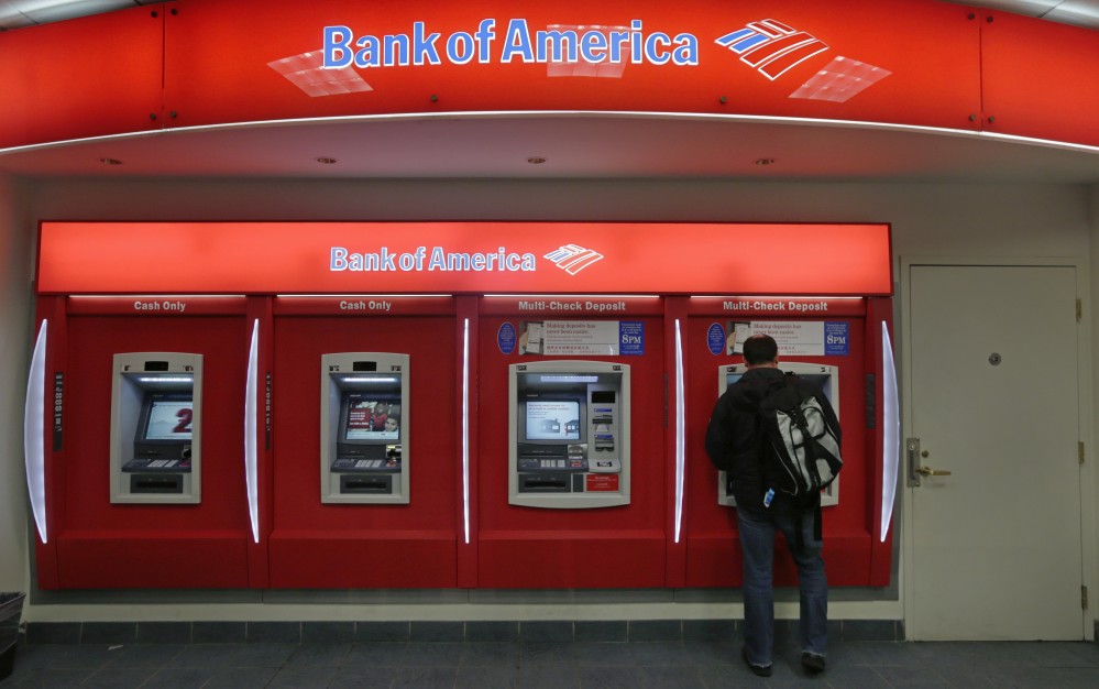 FILE - In this Dec. 13, 2012 file photo, a customer stops at a Bank of America ATM office in Boston.  Big banks aren't banking much in the way of profits. Energy loans turning bad, low interest rates and volatile markets are dragging down first quarter results for the nation's biggest banks and making the financial sector the worst performing part of the stock market. (AP Photo/Charles Krupa)