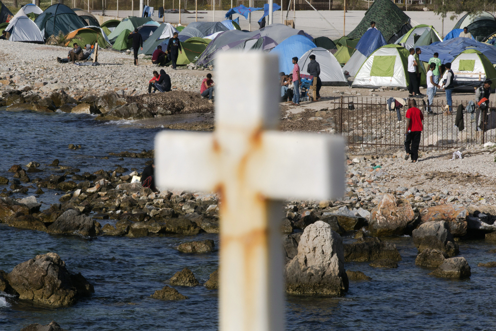 Refugees are seen on a beach in a camp that houses 2,300 people detained near Mytilene, in the Greek island of Lesbos, on Friday. Pope Francis will visit the camp Saturday.