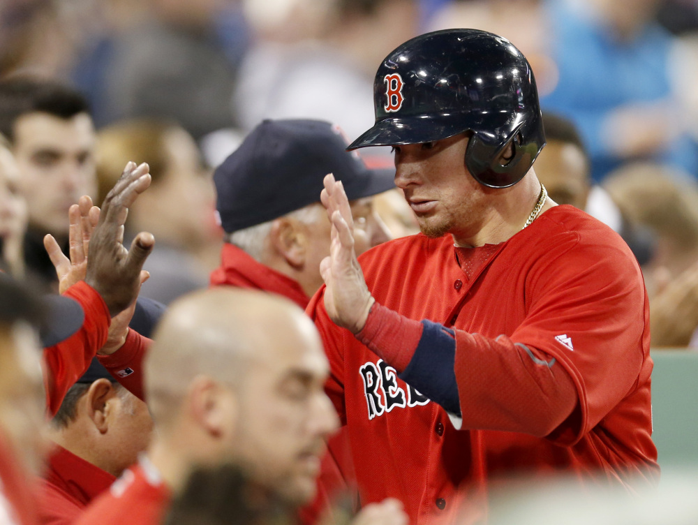 Boston's Christian Vazquez is congratulated at the dugout after scoring on an RBI single by Dustin Pedroia in the sixth inning Friday night at Boston against the Toronto Blue Jays.