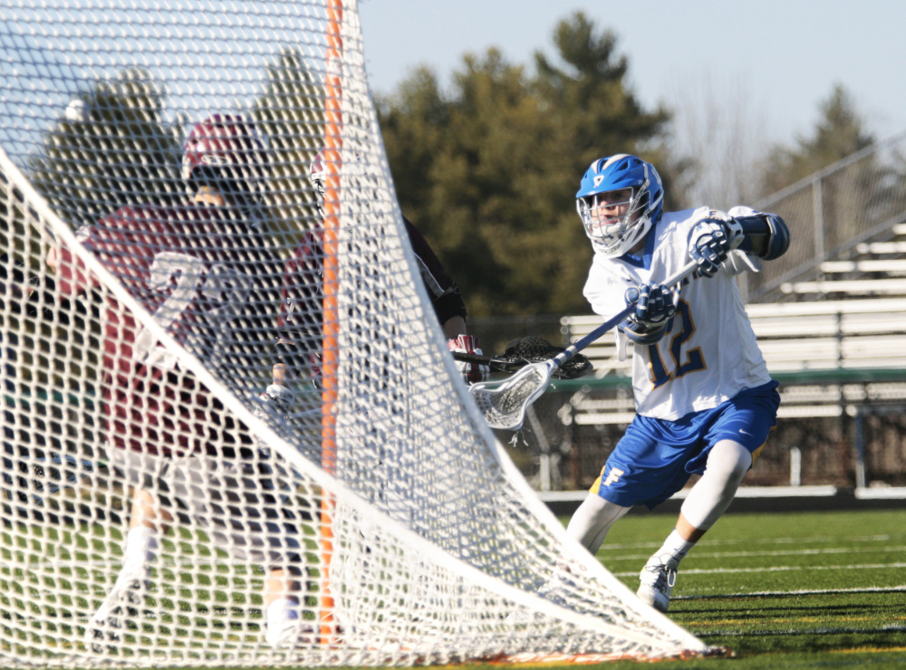 Lou Mainella of Falmouth attempts to slip a shot past Freeport goalie Zac Wogan during Falmouth's 19-6 victory in a boys' lacrosse opener Friday.The shot hit the far post and popped out.