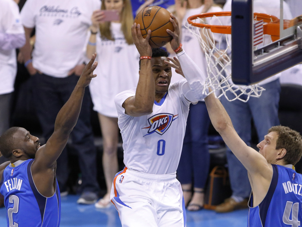Oklahoma City's Russell Westbrook splits the Dallas defense of Raymond Felton, left, and Dirk Nowitzki during an 85-84 win by the Mavericks in Game 2 of their first-round playoff series Monday at Oklahoma City.