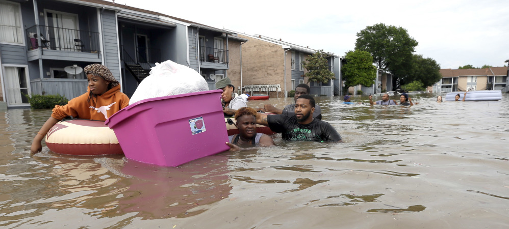 Residents wade through floodwaters as they evacuate their Houston apartment complex Monday after storms dumped more than a foot of rain on the nation's fourth largest city.