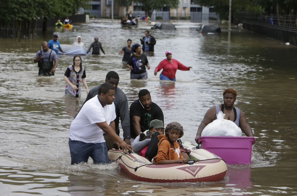 People evacuate from Arbor Court Apartments in the Greenspoint area Monday, April 18, 2016, in Houston. Massive flooding has become nearly an annual rite of passage in Houston, which is grappling with destroyed homes, trapped drivers and deaths for the third straight year. (Melissa Phillip/Houston Chronicle via AP) MANDATORY CREDIT