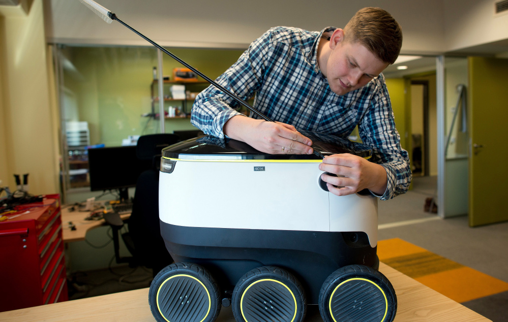 An engineer adjusts the antenna of a delivery robot at the headquarters of Starship Technologies in Estonia.