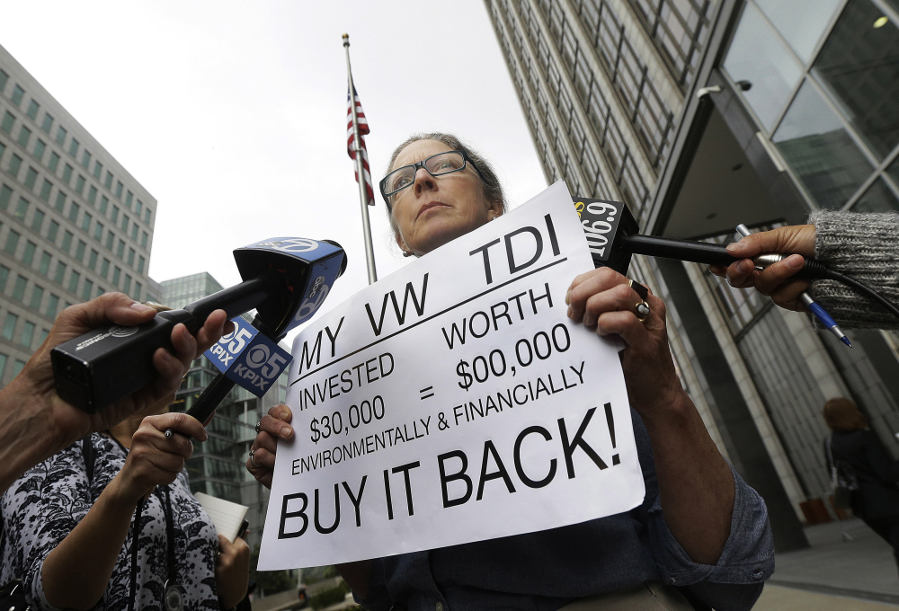 Joyce Ertel Hulbert, owner of a 2015 Volkswagen Golf, holds a sign outside the Phillip Burton Federal Building in San Francisco, on Thursday. And relate to news of the day: An agreement will give consumers who bought nearly 600,000 Volkswagen vehicles rigged to cheat on emissions tests the option of having the automaker buy back the cars or fix them, a judge said Thursday.