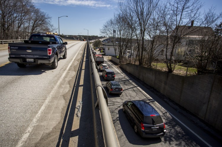 A Maine Department of Transportation truck sits on the Route 1 viaduct in Bath during a bridge inspection as traffic packs Commercial Street below.