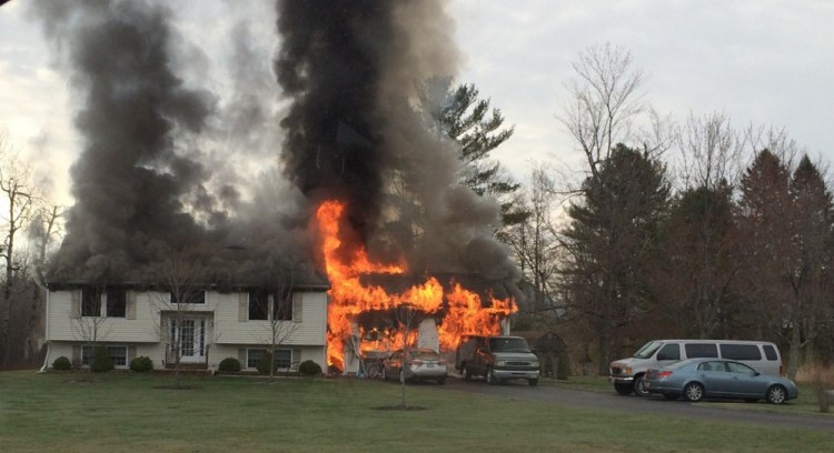 Flames engulf a home at 3 Bradley Road in Vassalboro on Friday morning.