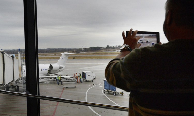 David Laliberte of Palm Bay, Fla., takes a picture of an Elite Airways jet at the Portland International Jetport in December, just after the carrier started offering flights between Portland and Melbourne, Fla. Now Elite is expanding its Portland service. In June, the carrier will start flying to Long Island, N.Y., and Bar Harbor twice a week. Elite's business model is based on serving snowbird populations who head south for the winter and north for the summer. 
2015 Telegram file/Shawn Patrick Ouellette