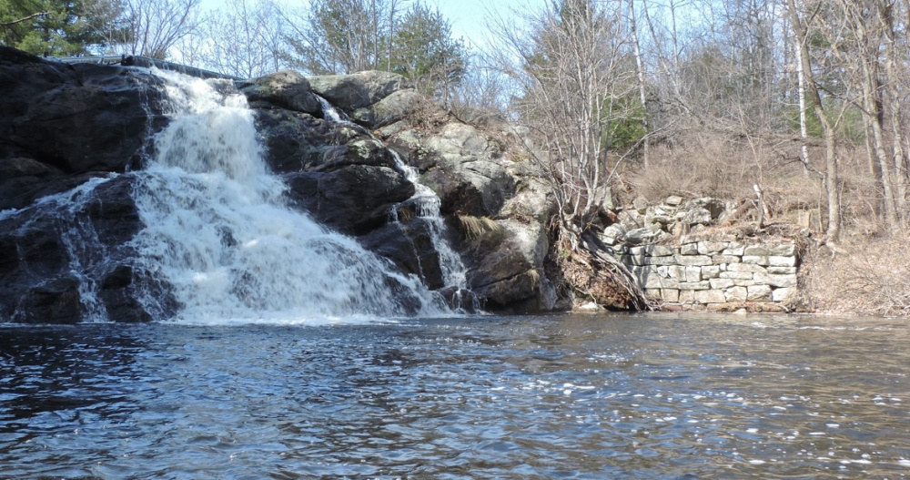 A waterfall at the western end of the reservoir and a rock wall from an old sawmill are highlights of a paddle in the Saco River Reservoir.