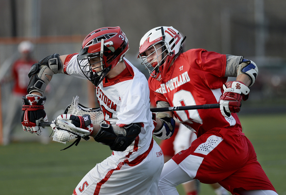 Scarborough's John Stolz, left, drives with the ball as Finn Zechman of South Portland chases him Friday during Scarborough's 13-10 boys' lacrosse victory.