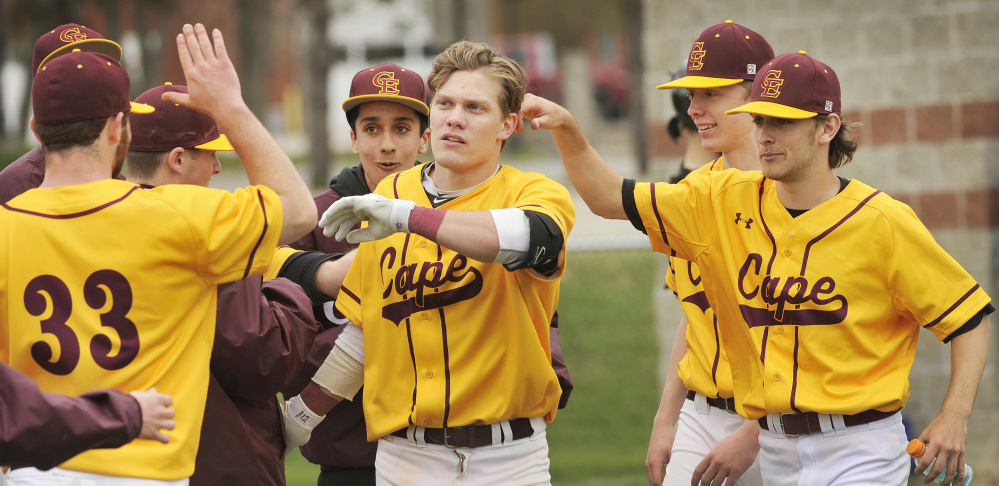 Cape Elizabeth's Dylan Roberts is greeted at home plate by his teammates after hitting a home run in the sixth inning Saturday against Kennebunk. The Capers won their season opener, 6-1.