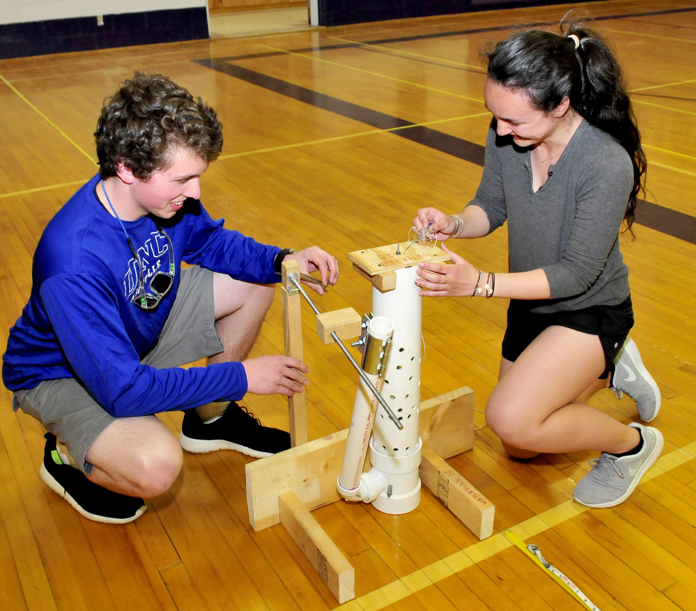 Waterville Science Olympiad team members John Violette and Nora Greene assemble an air trajectory device that will launch a ball during competition in May.