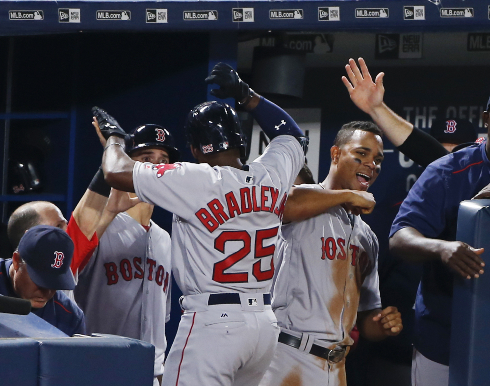 Jackie Bradley Jr. celebrates with Xander Bogaerts after hitting a solo home run against the Braves for the game's only run.