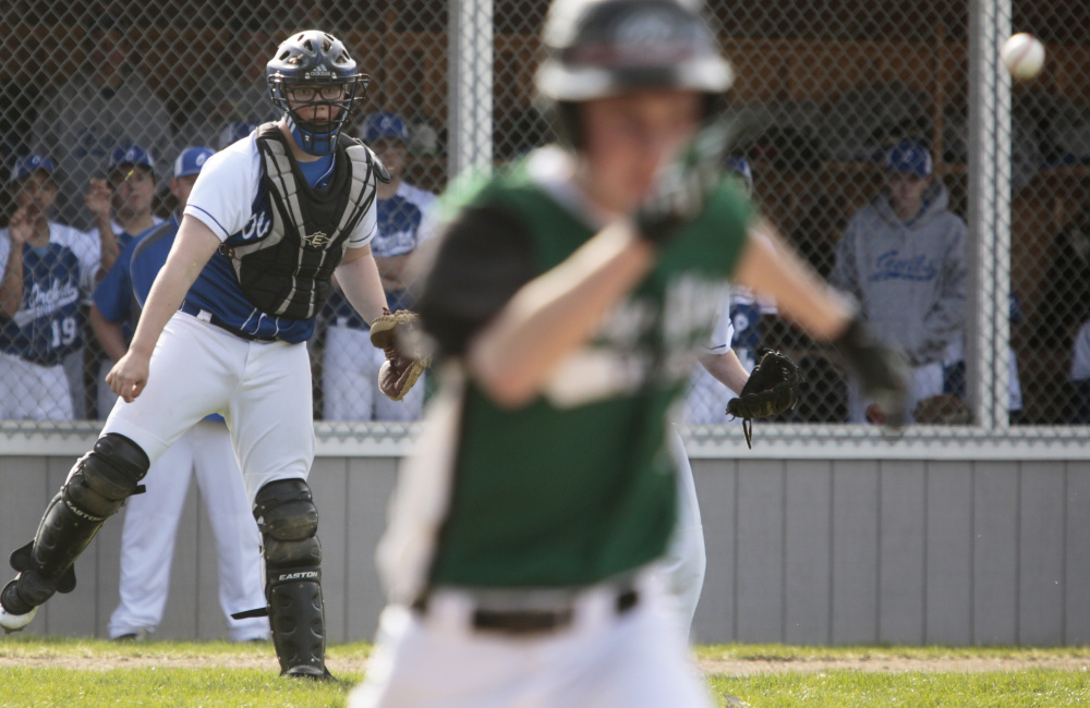 Max Winson of Waynflete heads to first base Monday as Old Orchard Beach catcher Evan O'Donnell watches his throw get there in time. Old Orchard pulled away to a 9-1 victory.