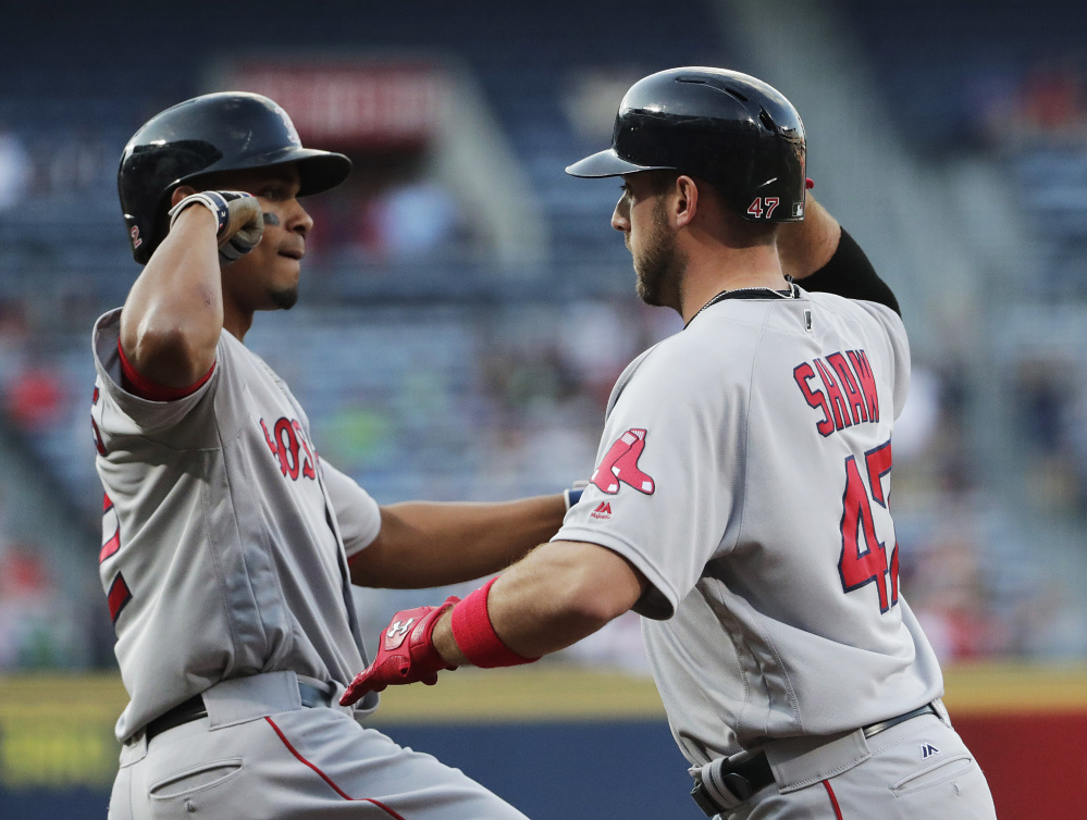 Boston's Travis Shaw, right, high-fives teammate Xander Bogaerts after hitting a three-run home run in the first inning of Tuesday's game against the Atlanta Braves. (Photos by The Associated Press)
